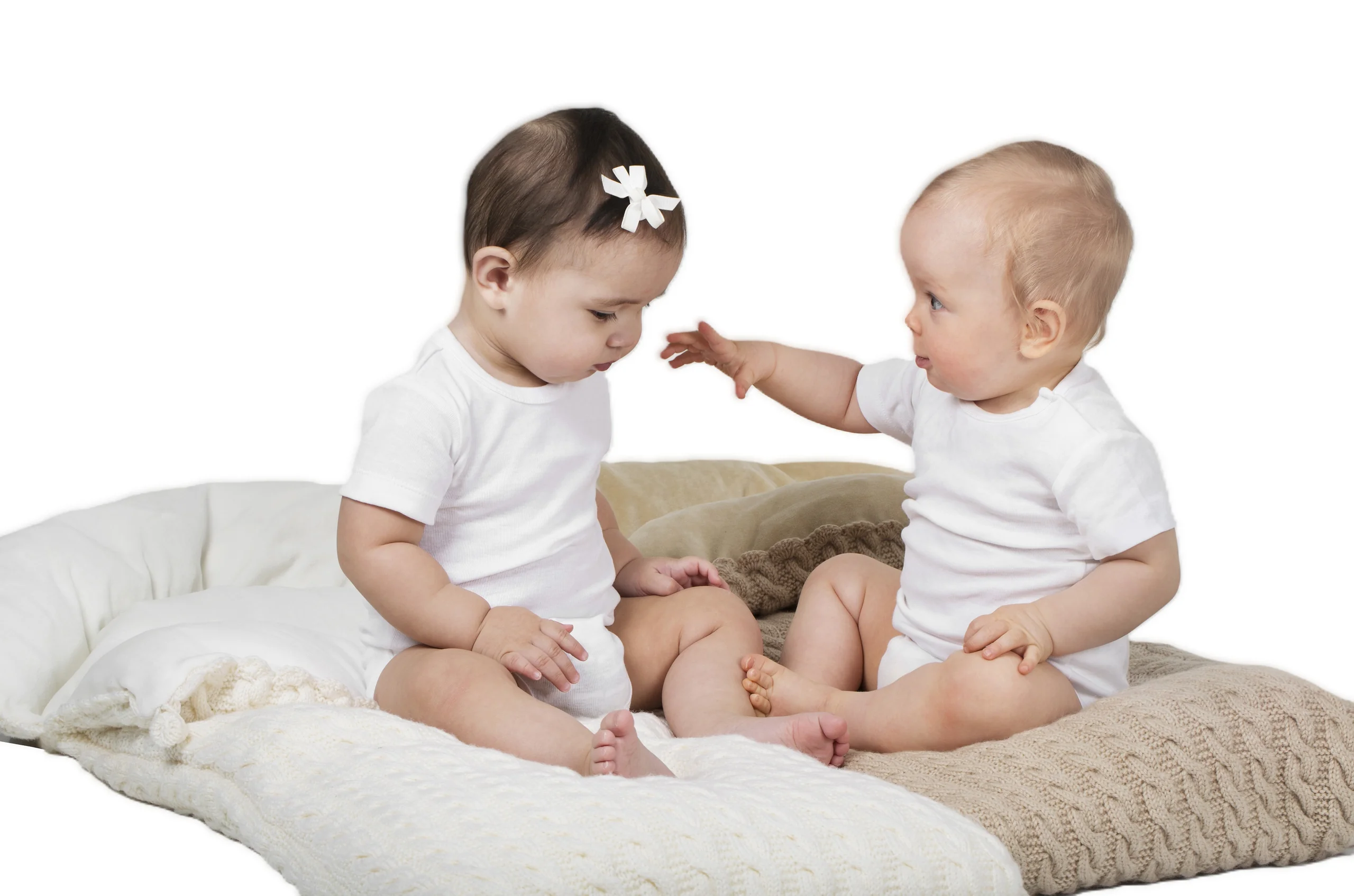 To babyer sitter på vognposer i krem og beige